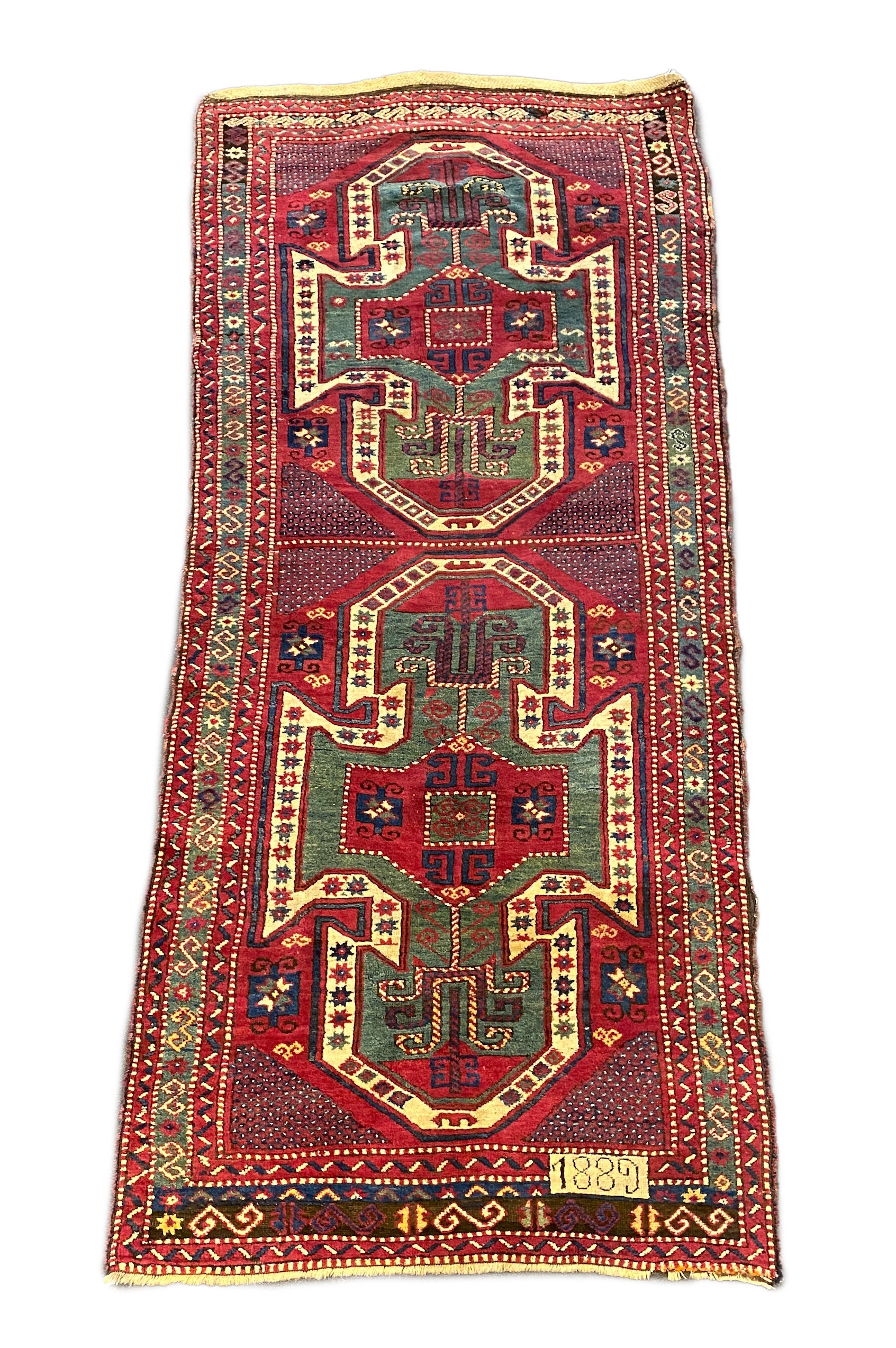 An antique Kazak red ground rug, 280 x 120cm